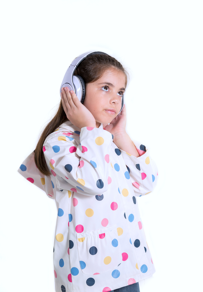 A photo of a little girl with headphones on.